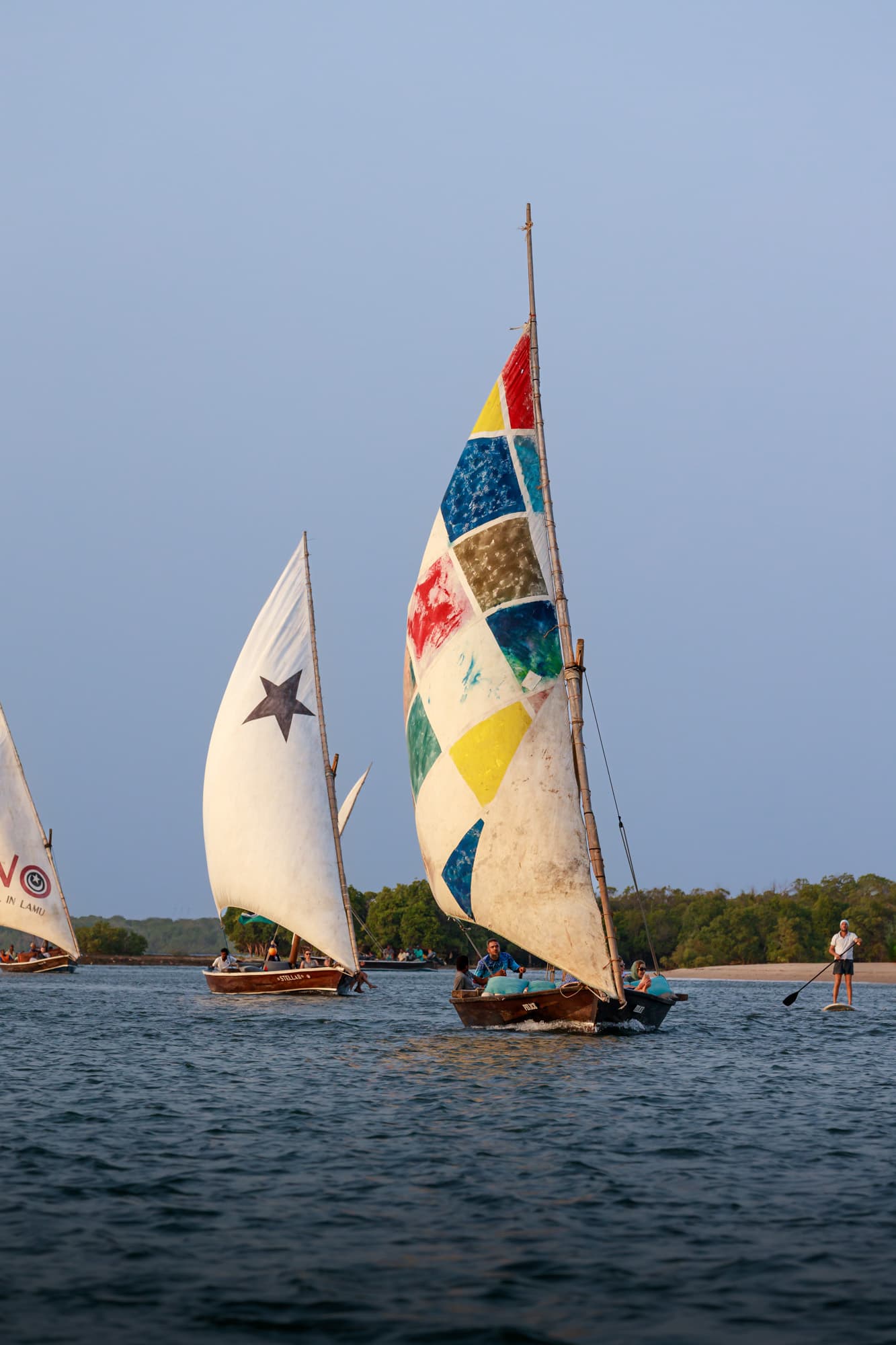 Dhow sailing with a paddleboarder nearby